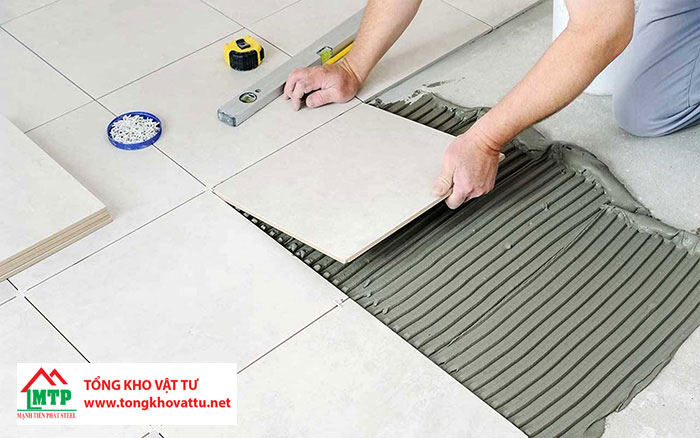 Dán gạch lên lớp keo và ấn mạnh